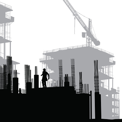 Construction worker walking through rebar on the foundations of a large building to be built