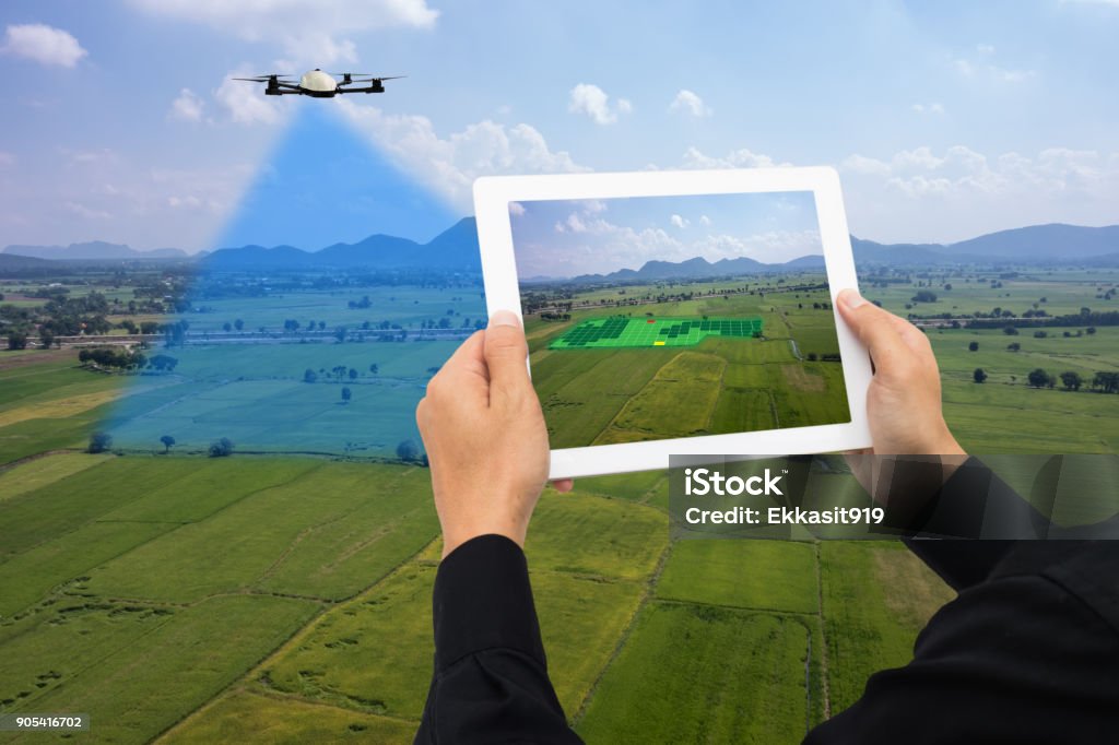 drone for agriculture, drone use for various fields like research analysis, safety,rescue, terrain scanning technology, monitoring soil hydration ,yield problem and send data to smart farmer on tablet Drone Stock Photo