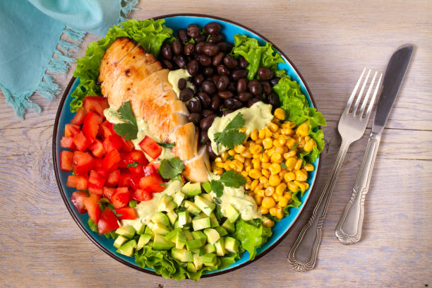 istock Chicken dish with nutritious selection of vegetables: avocado, beans, tomatoes and sweet corn. Chicken breast salad 905417636