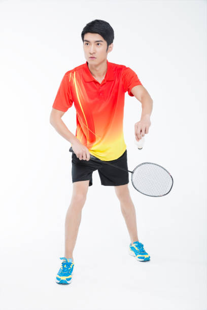 istock young man playing badminton over white background 905421398