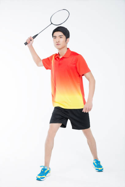 istock young man playing badminton over white background 905421490