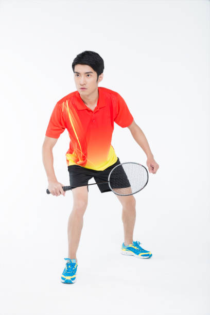 istock young man playing badminton over white background 905421492