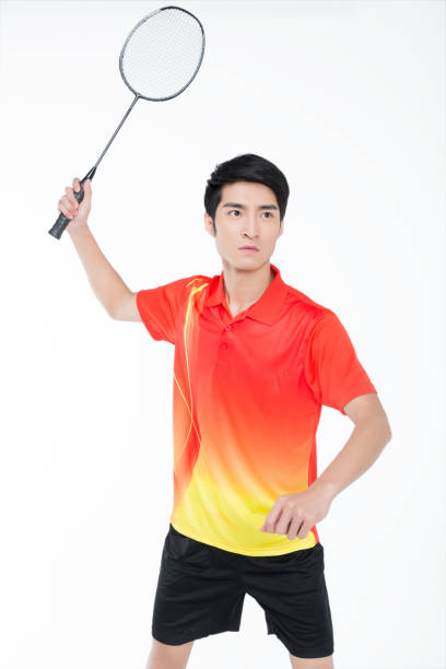istock young man playing badminton over white background 905421590