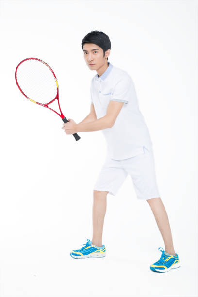 istock young man playing tennis over white background 905422322
