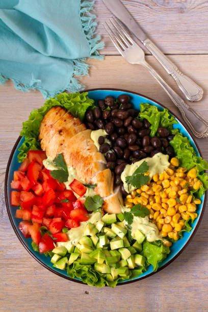 istock Chicken dish with nutritious selection of vegetables: avocado, beans, tomatoes and sweet corn. Chicken breast salad 905424952