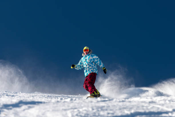 snowboarder at ski slope against blue sky - ski jumping snowboarding snowboard jumping imagens e fotografias de stock