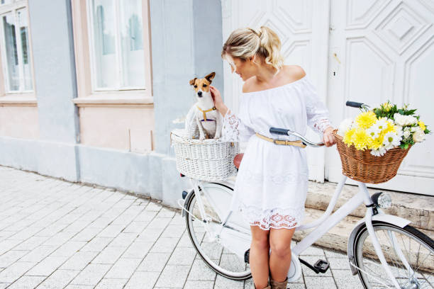 町で自転車に乗って、美しい、ブロンドの女性 - floral dress ストックフォトと画像