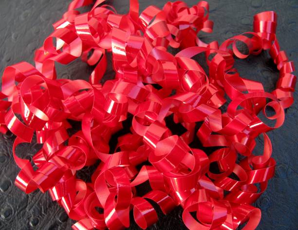 istock Red twirled party or gift ribbons over a black background 905438322