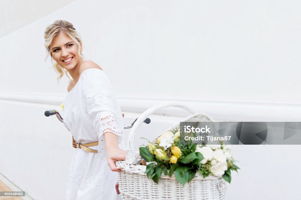 Beautiful, blond woman riding a bicycle in a town Adult Stock Photo