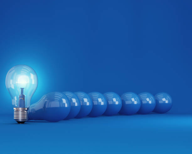 istock Row of light bulbs with glowing one different idea from the others on blue background, Minimal concept idea. 905439870