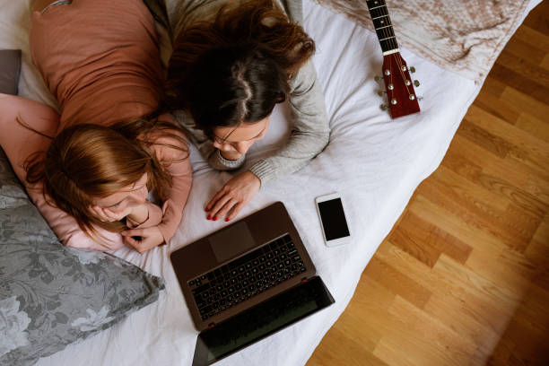 istock Gorgeous friends using the laptop in the bedroom. 905445604