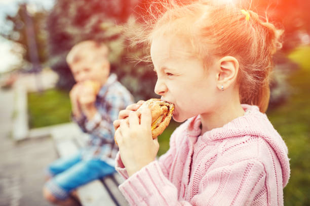 istock Children on in the park eating a burger 905448514