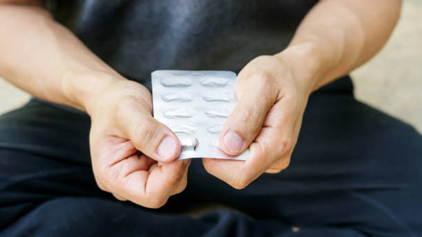 istock Man holding a white pill capsule. 905449060