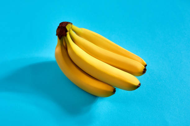 istock Yellow ripe bananas on blue background with space for text or design. Top view 905450006