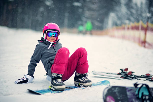 kleines mädchen snowboarden zu lernen - snowboardfahren stock-fotos und bilder