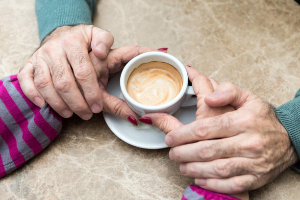 istock Senior couple holding hand drinking morning coffee 905457442