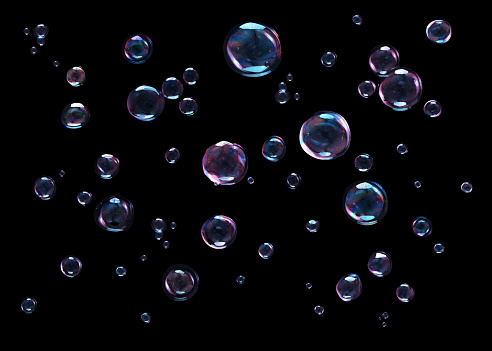 Colored soap bubbles flying on black background