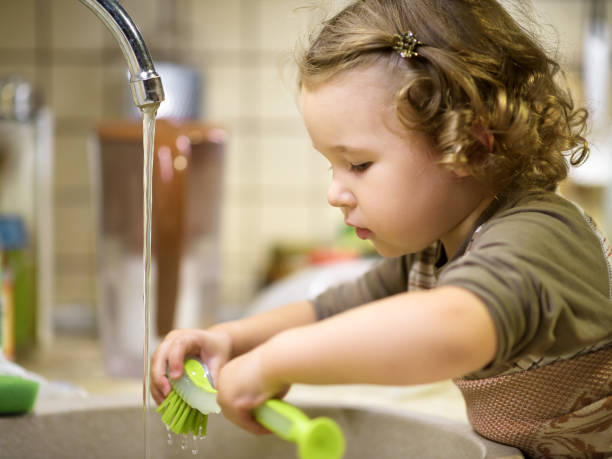 istock Pretty two-year girl washes the dishes 905458094