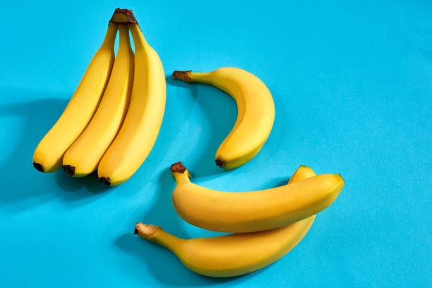 istock Yellow ripe bananas on blue background with space for text or design. Top view 905461608
