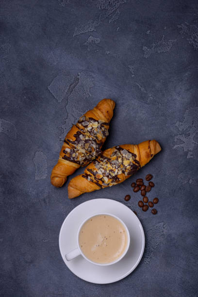 istock Cappuccino and croissants with toping from chocolate and almonds 905465100