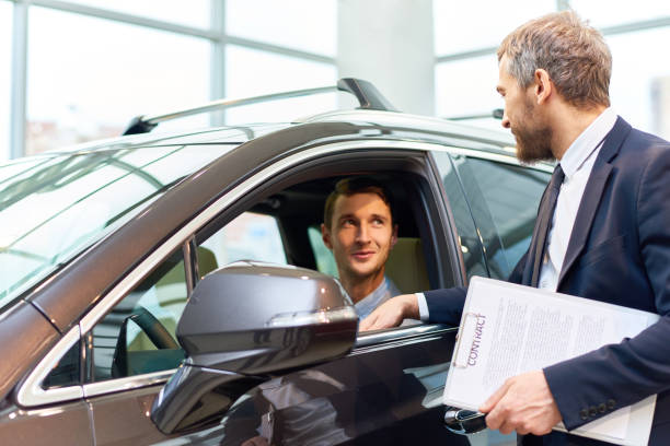 istock Young Man Testing New Car in Showroom 905467942