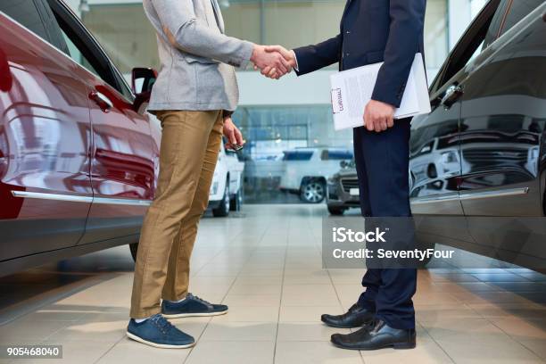 People Shaking Hands In Car Showroom Stock Photo - Download Image Now - Car, Car Salesperson, Car Dealership