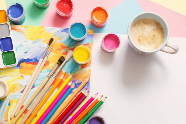 istock cup of coffee and paints, pencils on white background 905468452