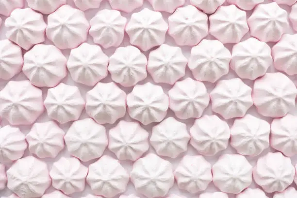 Pink strawberry mini meringues as food background. Top view.