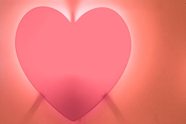 istock Pink heart-shaped fire on red background on orange 905473400