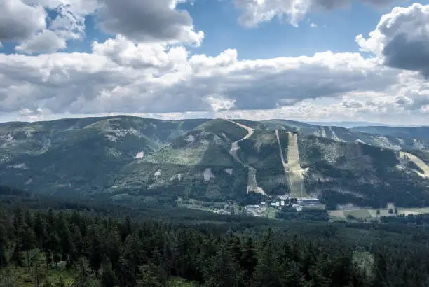 Dolni Morava resort with hills of Kralicky Sneznik mountains around in Czech republic from Klepac hill during summer day with blue sky and clouds