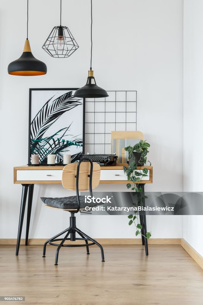 Home office interior with typewriter Modern retro style desk and chair in cozy white home office interior with vintage typewriter, plant and poster Home Office Stock Photo