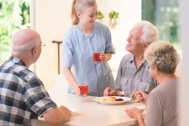 istock Volunteer and senior eating lunch 905476864