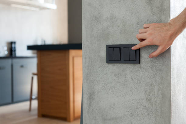 istock Close up of finger is turning on or off on light switch. Copy space. 905477520