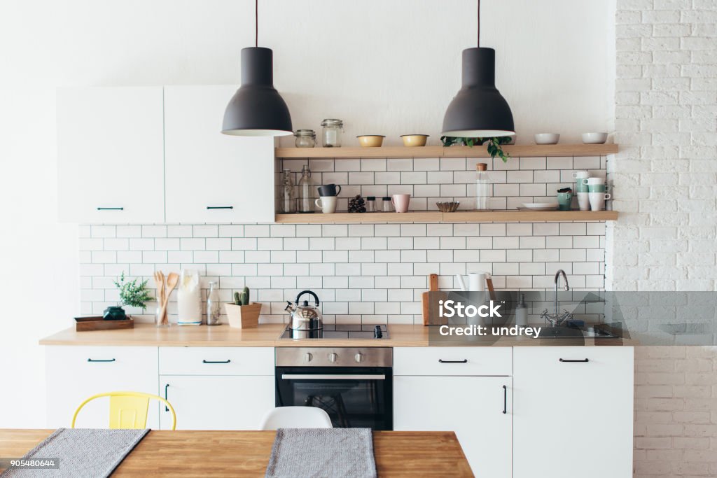 Moderno nuovo interno leggero della cucina con mobili bianchi e tavolo da pranzo. - Foto stock royalty-free di Cucina