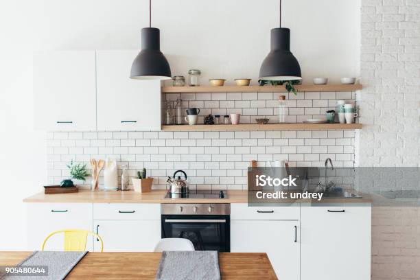 Modern New Light Interior Of Kitchen With White Furniture And Dining Table Stock Photo - Download Image Now