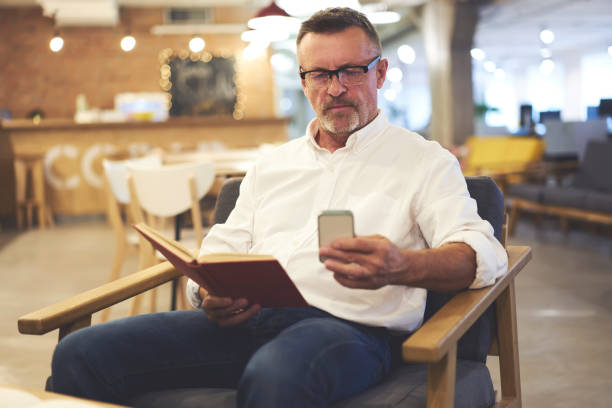 istock Talented experienced male journalist blogging his website writing article review about book sharing his opinion with followers using smartphone and wireless connection to 4G internet in coffe shop 905480908