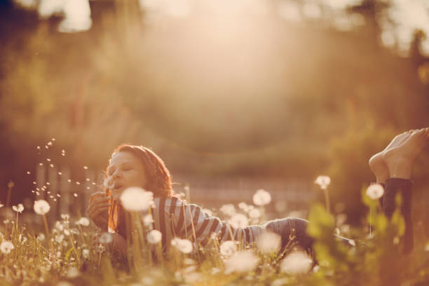 istock Woman blowing dandelion 905483674
