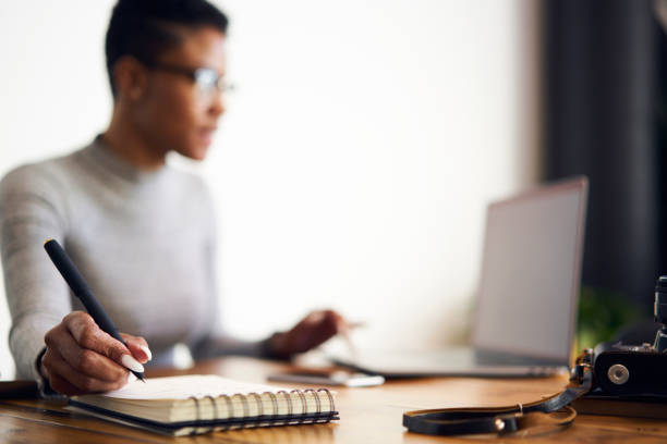Female administrative making checklist of completed tasks of coworkers using notebook in office near stuff and copy space are for advertising content or messages, selective focus on hand writing