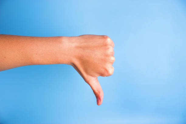 istock Closeup of woman's hand gesturing thumbs down 905484388