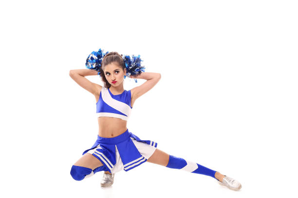 istock Young cheerleader in blue and white suit with pompoms on white background. Isolated on white background. 905488536