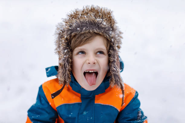 istock Happy kid boy having fun with snow in winter 905497636