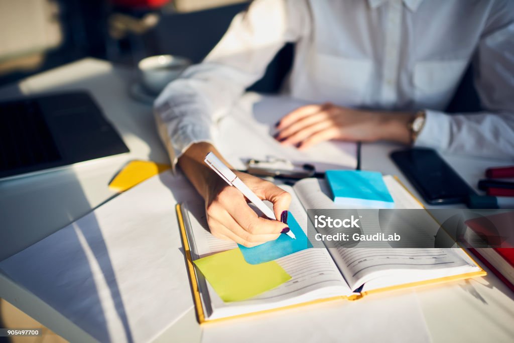 Cropped image of creative female secretary creating planning for executive noting important meeting and events organizing work of busy boss while sitting at working place in coworking office Preparation Stock Photo