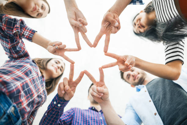 istock Five young smiling people make star shape from fingers 905499124
