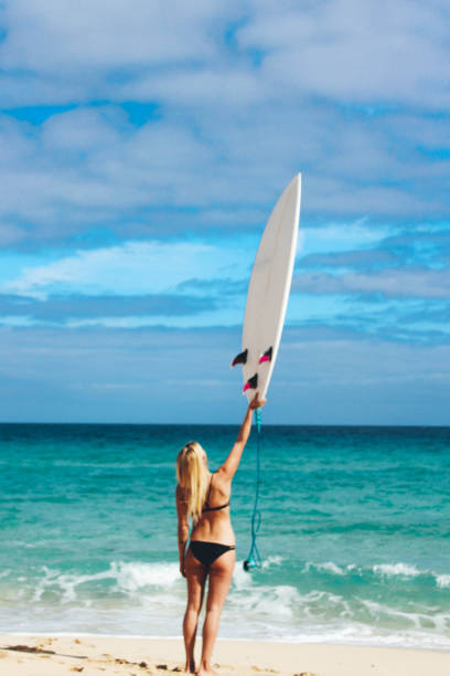 istock Surfer girl on the beach holding surfboard 905500642