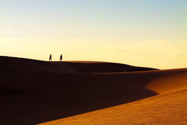 istock Two tourists walking at sand desert in Maspalomas on Gran Canaria. 905501512