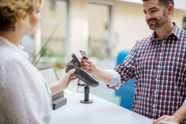 istock Mid adult man paying contactless using credit card 905504652
