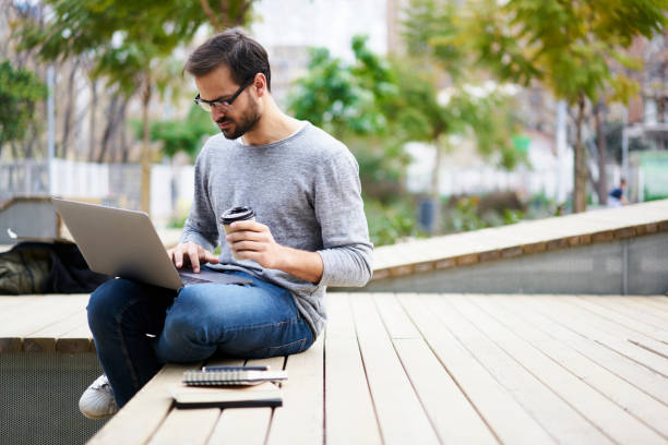 istock Skilled male copywriter preparing proofreading copy to check spelling and grammar mistakes working outdoors enjoying coffee concentrated on task using laptop computer and 5G wireless connection 905504674