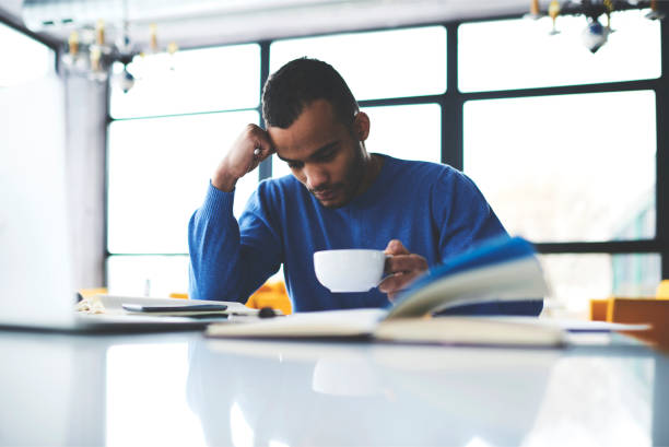 istock Pensive afro american student concentrated on analyzing new information learning with coffee, intelligent dark skinned businessman  pondering on finding solution of startup problem during break 905514280