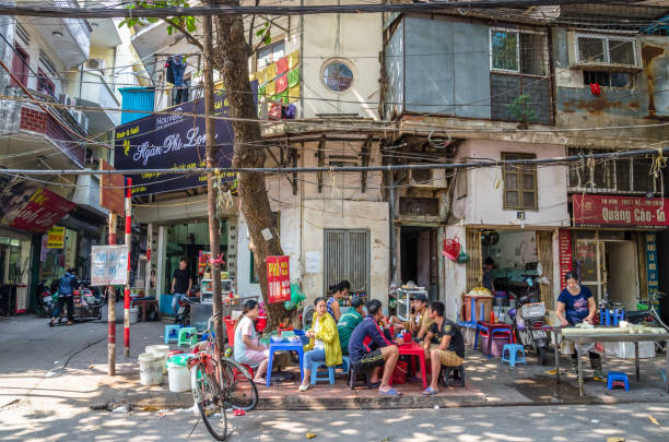 People can seen having their food beside the street in the morning at Hanoi, Vietnam. stock photo
