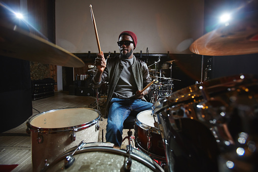 Contemporary and popular African-american musician playing drums during repetition